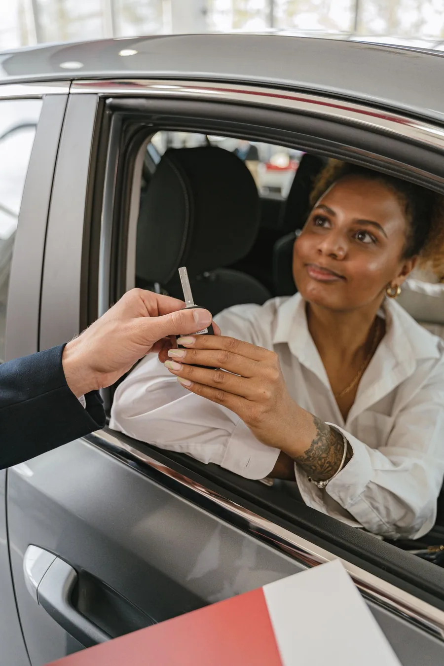 Driver receiving car keys after completing Colorado SR-22 auto insurance paperwork in Denver