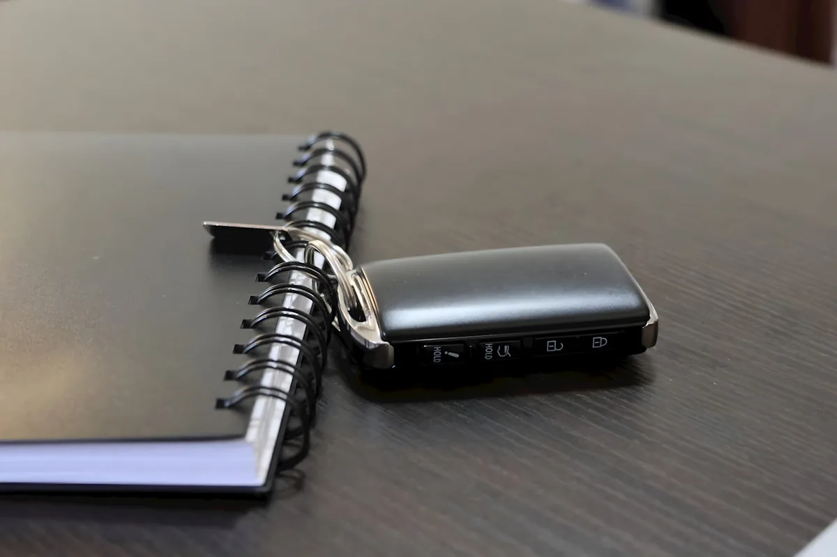 Car key fob resting on a notebook of Denver SR-22 auto insurance notes